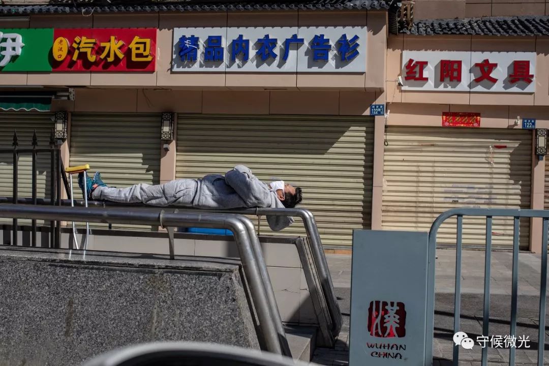 2月16日,湖北省武汉市,利济路上,一名市民躺在栏杆上晒太阳。中国青年报李隽辉/摄