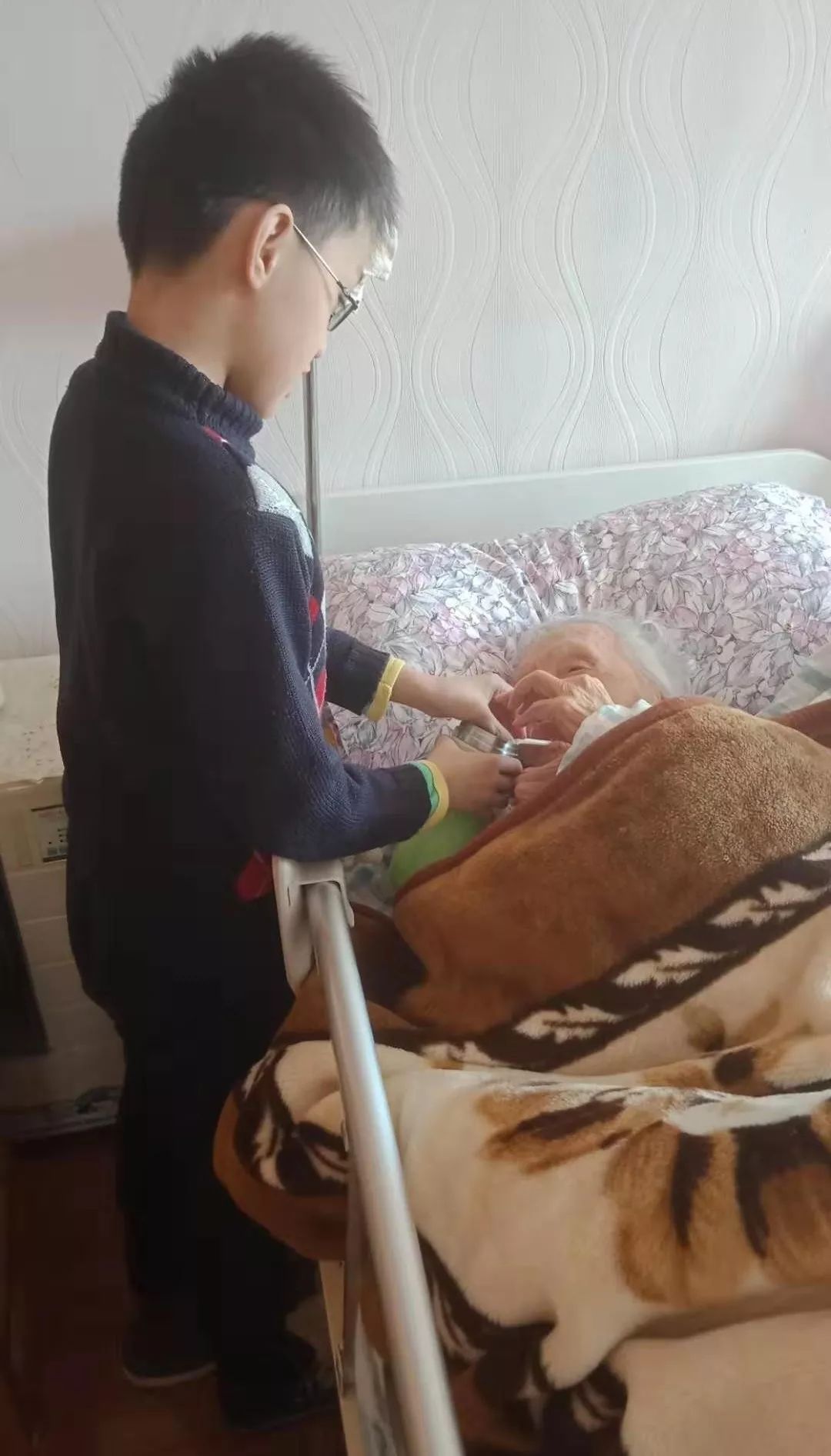  冯亮的小儿子魏鸿也会做事了，给太太热饭，喂太太喝水 受访者供图