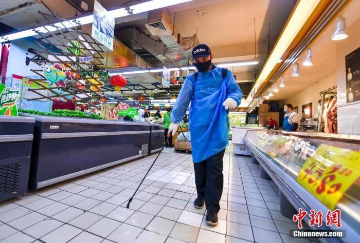 资料图：超市工作人员在喷洒消毒液。中新社记者 刘新 摄