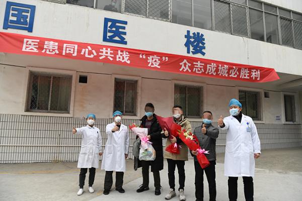 2月5日15时30分许,十堰市国药东风总医院医务人员送别治愈患者,并与其中三名患者合影。 图片来源:十堰市国药东风总医院