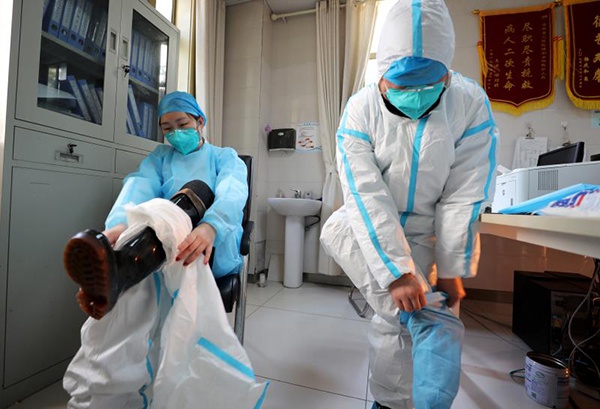 罗信渠和助手在穿戴防护装备。