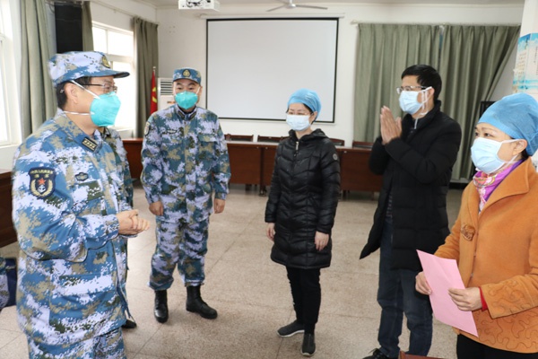 武汉汉口医院副院长王琼娅（中）与援鄂广东医疗队成员对接工作。