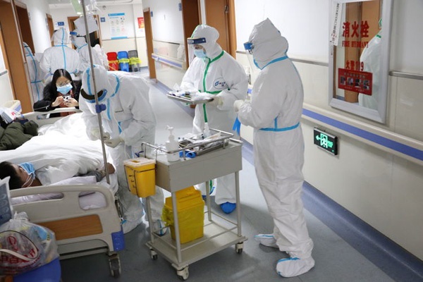 武汉汉口医院医护人员给在走廊加床的患者治疗。