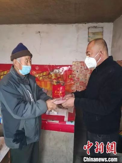 图为高治邦将30000元现金交到村委会工作人员手中。缸房窑村村委会供图
