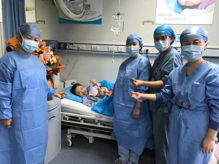 李伟妻子抱着宝宝向镜头比心