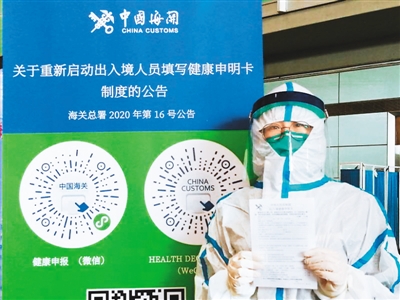 海关工作人员展示第四版《中华人民共和国出入境健康申明卡》。