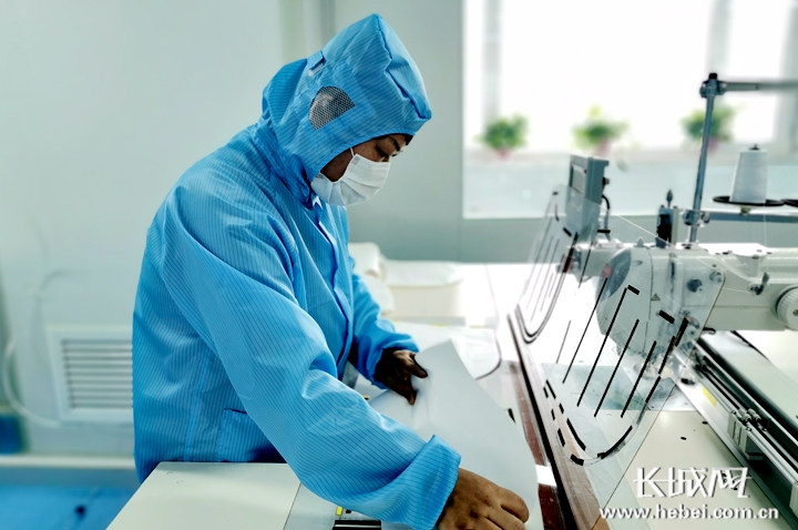 工人操纵自动缝纫模板机。 记者 信贺宁 摄