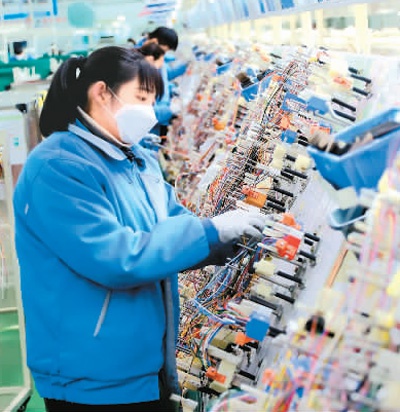 2月26日,山东省青岛西海岸新区一家企业员工正在生产线上制作汽车线束。 王培珂摄(新华社发)