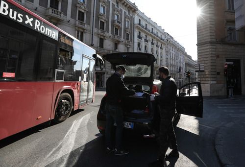 3月16日，在意大利首都罗马，两名便衣警察查验人们出行的“自我声明”以及身份证件。新华社记者 程婷婷 摄
