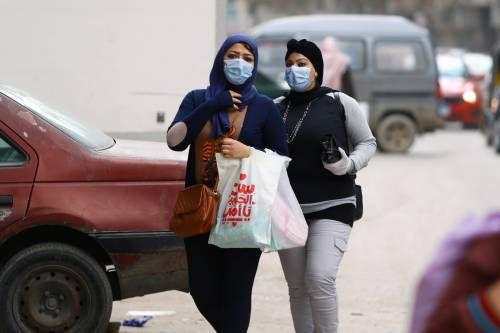 图为3月17日，2名戴着口罩的女子走在埃及开罗的街头。新华社发