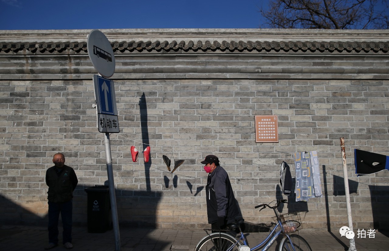  △3月1日，柳荫街，两位居民在墙边晒太阳。摄影/新京报记者薛珺