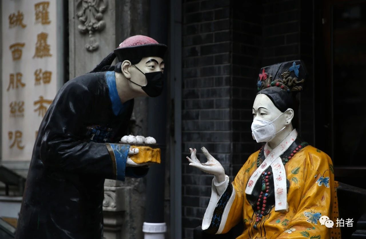  △2月29日，大栅栏商业街，路边的塑像被人戴上了口罩。摄影/新京报记者薛珺