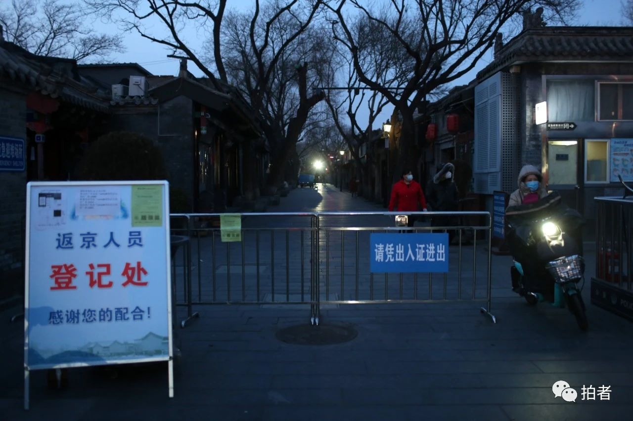 △2月26日，南锣鼓巷，一位居民骑车出胡同。因疫情防控需要，南锣鼓巷暂停接待游客。摄影/新京报记者薛珺