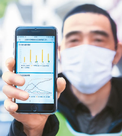2月20日，在浙江省杭州市富阳区上官乡芳村检查点，工作人员展示手机上的“疫情防控云图”的实时数据。 　　新华社记者 徐 昱摄