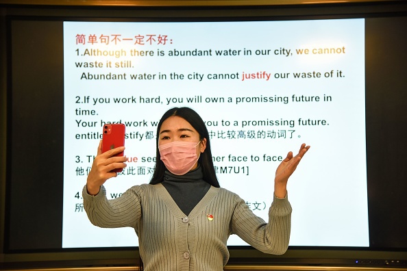 资料图片：2月17日，中国江苏省东海县一所中学的教师通过智能手机给学生在线上课。（法新社）