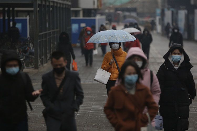 下班途中的市民撑起雨伞。