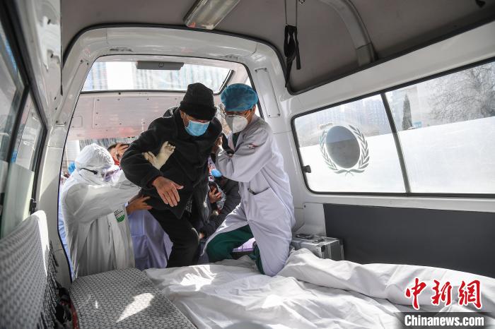 医护人员护送86岁的新冠肺炎患者张先生上车。 武俊杰 摄