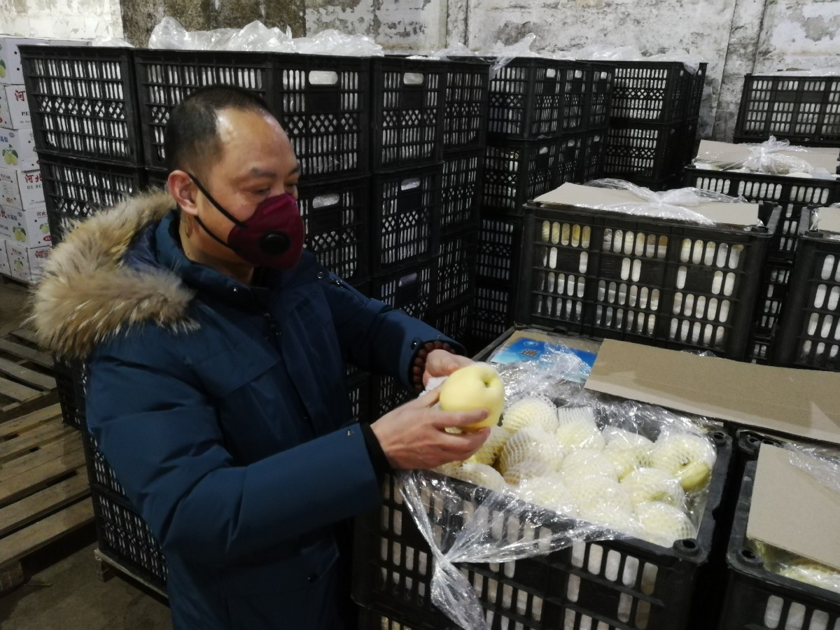 张云春在仓库检查果蔬质量。