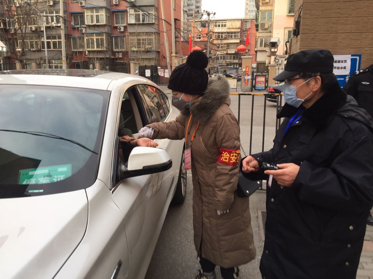 王玥在社区站岗为居民测量体温。