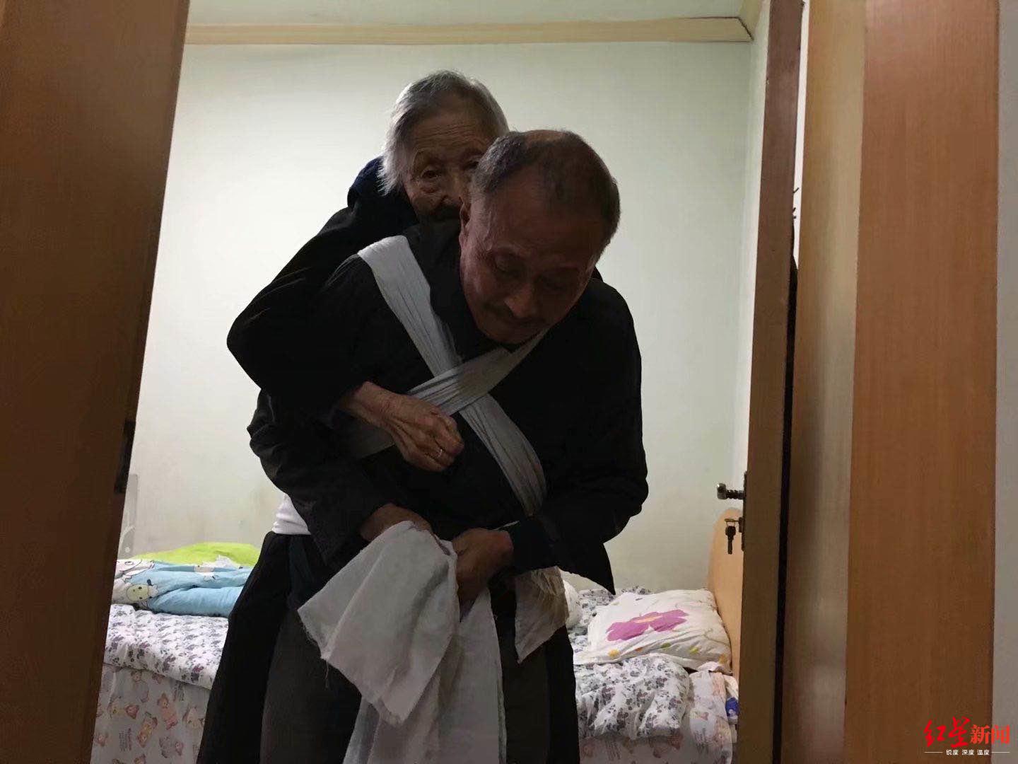 ↑吴国元背母亲出门。