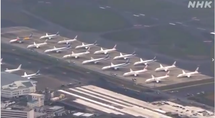 新冠肺炎疫情影响下，羽田机场停机坪上飞机紧密排排坐的景象。 　　图片来源：NHK视频截图