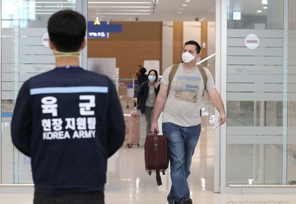 资料图：一名外籍人员戴口罩现身韩国机场
