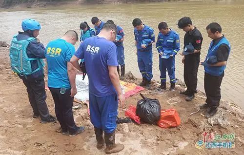 图为救援人员向溺亡小孩默哀