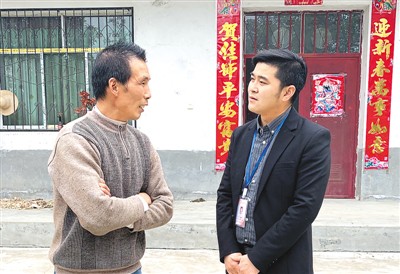 杨泽（右）与村民交谈。本报记者 高 炳摄