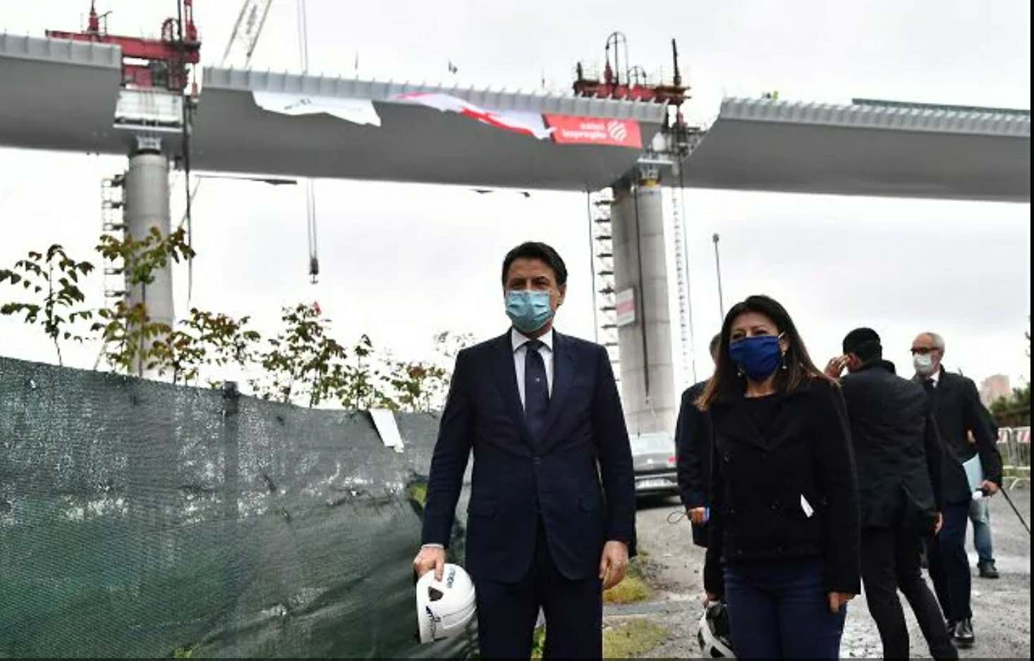 △意大利总理孔特(左一)出席大桥合龙仪式(图片来源:安莎社)