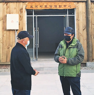 吉色方森（右）与昭觉县住建局局长在商量三河村新村文旅产业发展。雪 龙摄