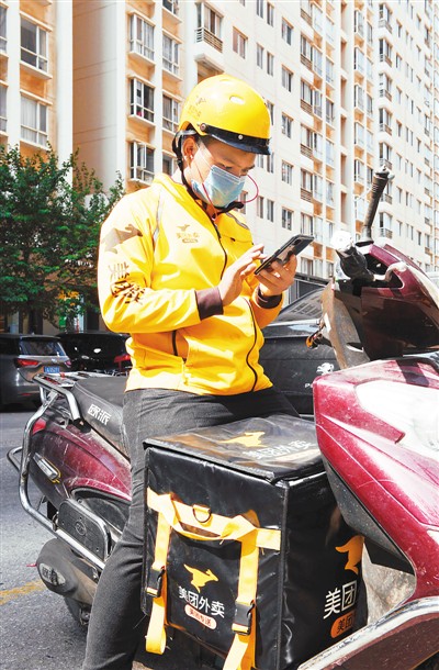 图为三月十六日，美团骑手吕连彬在云南昆明街头接订单。新华社记者 杨宗友摄