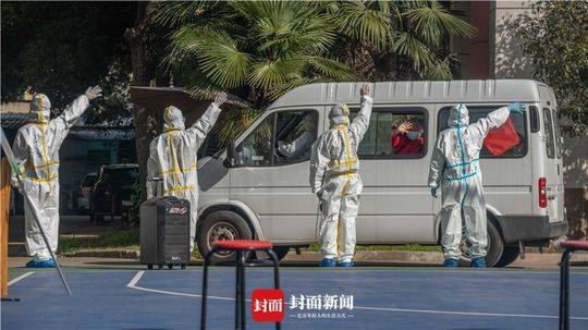 自愿者和病愈病人相互挥手作别