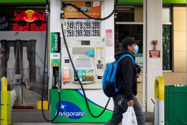 4月20日，一名戴口罩的男子从美国纽约一家加油站的油泵旁走过。 新华社发（郭克摄）