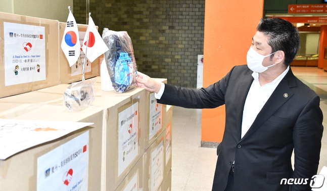 收到韩国庆州捐赠的物资后，日本奈良市长仔细查看。（news 1）