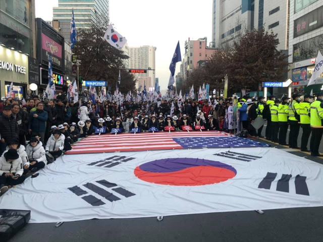 2018年12月,支持者集会声援朴槿惠,星条旗铺一地。(韩国《每日新闻》)