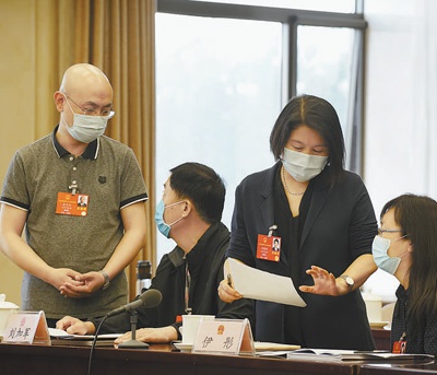 十三届全国人大三次会议北京代表团举行分组审议,代表们利用会间休息时间相互交流讨论议案。本报记者 黄 超 左 潇摄影报道