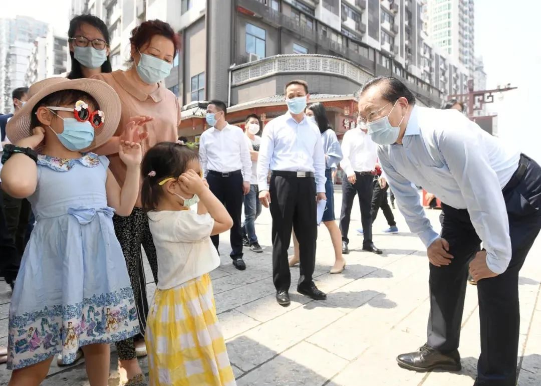 5月2日,汉正街,王忠林和小游客打招呼交谈。图/《长江日报》