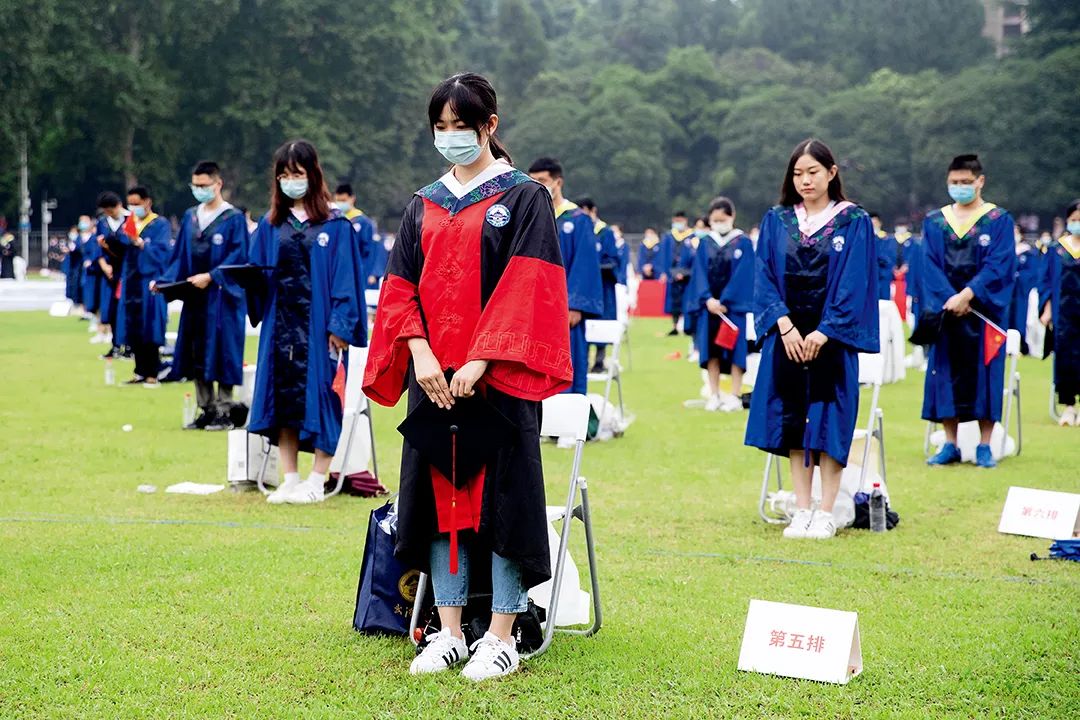 6月20日，武汉大学参加毕业典礼的师生为新冠肺炎牺牲烈士和逝世同胞默哀。当日，武汉大学举行一场特殊毕业典礼，660名毕业生代表在现场拨穗正冠，未能到场的毕业生则通过观看5G直播方式“云”聚珞珈，共同见证自己的毕业盛典。图/中新