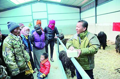 巴桑旺堆（右一）与牧民交流。资料图片