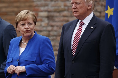资料图片：2017年5月25日，意大利陶尔米纳，德国总理默克尔（左）与美国总统特朗普在G7峰会上拍摄集体照。（美联社）