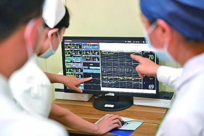 陕西西安,空军军医大学西京医院消化外科的医护人员通过中央站查看患者实时监测数据。新华社发