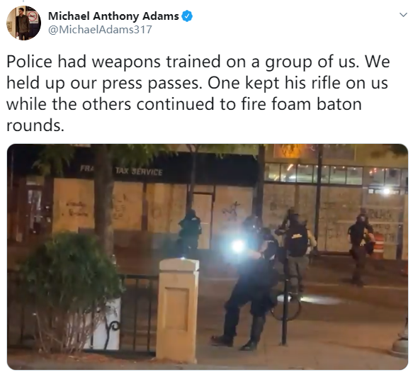 △迈克尔·亚当斯社交媒体发文:警察瞄准了我们,我们拿出记者证,一个人用步枪对着我们,其他人继续用泡沫弹射击。