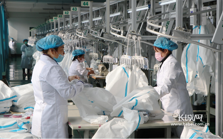 际华三五四三针织服饰有限公司生产车间内,工人们加班加点生产防护服。邢占山 摄