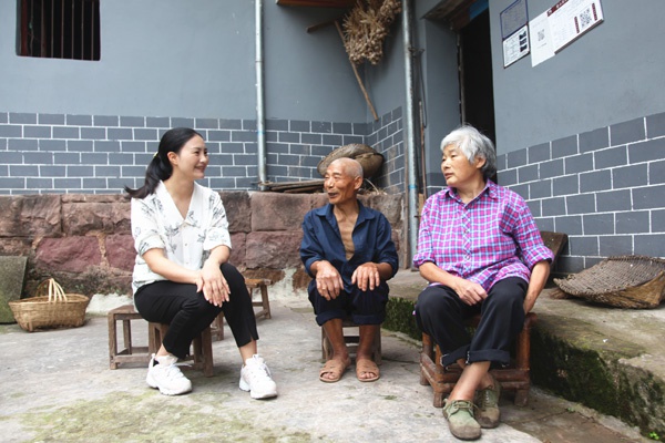 图為万阳(左)在群众家中领会扶贫政策落真相况。