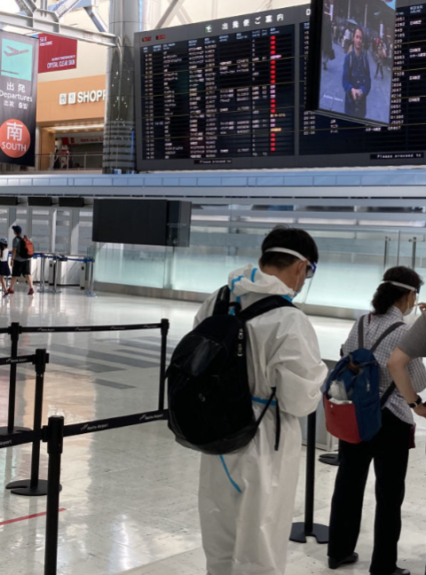 ▲成田机场,中国乘客身着白色防护服(西日本新闻)