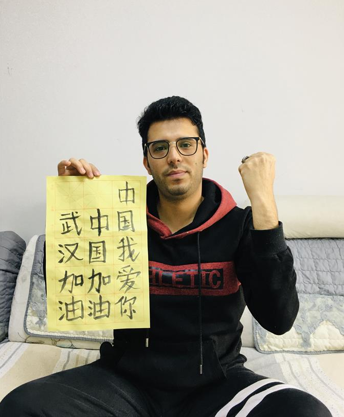 默丁在家中写毛笔字为中国加油(2月28日摄,受访者供图)。