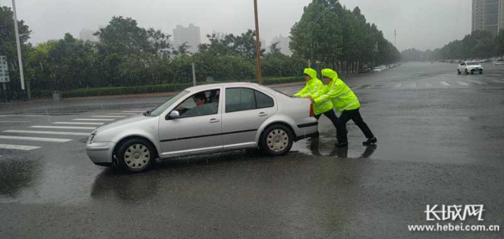 执勤民警冒雨为群众手推车。通讯员 黄鹏 供图