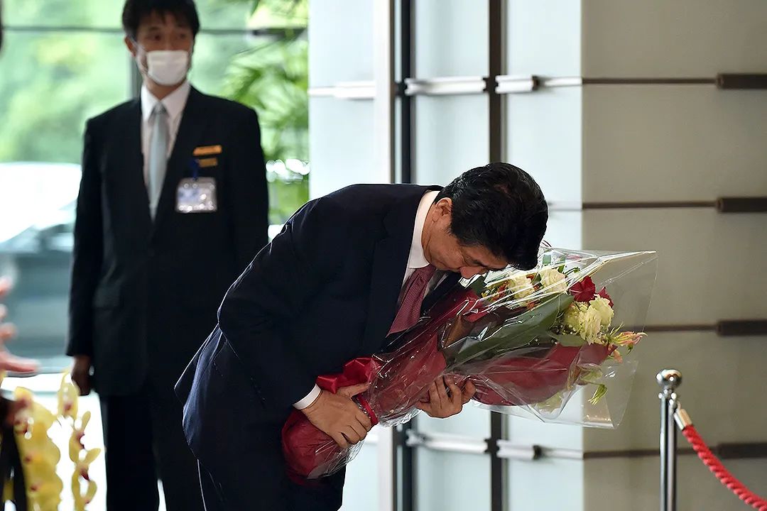 当天下午，安倍也搬离了首相官邸，新任首相菅义伟及官邸职员为其送行。图为安倍与工作人员告别，鞠躬致意。