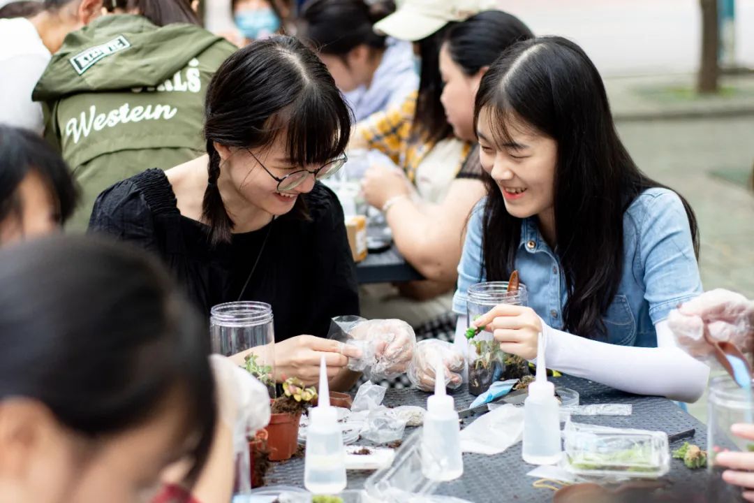 ▲新生欧倩茵在和她的同砚建造生态瓶的历程中有说有笑 (彭雨格 摄)
