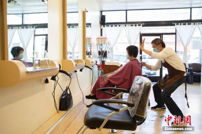 当地时间9月15日,顾客在美国旧金山一家理发店内理发。从14日开始,旧金山的理发店、美甲店、健身房以及酒店等商业店铺获准重启室内营业。中新社记者 刘关关 摄